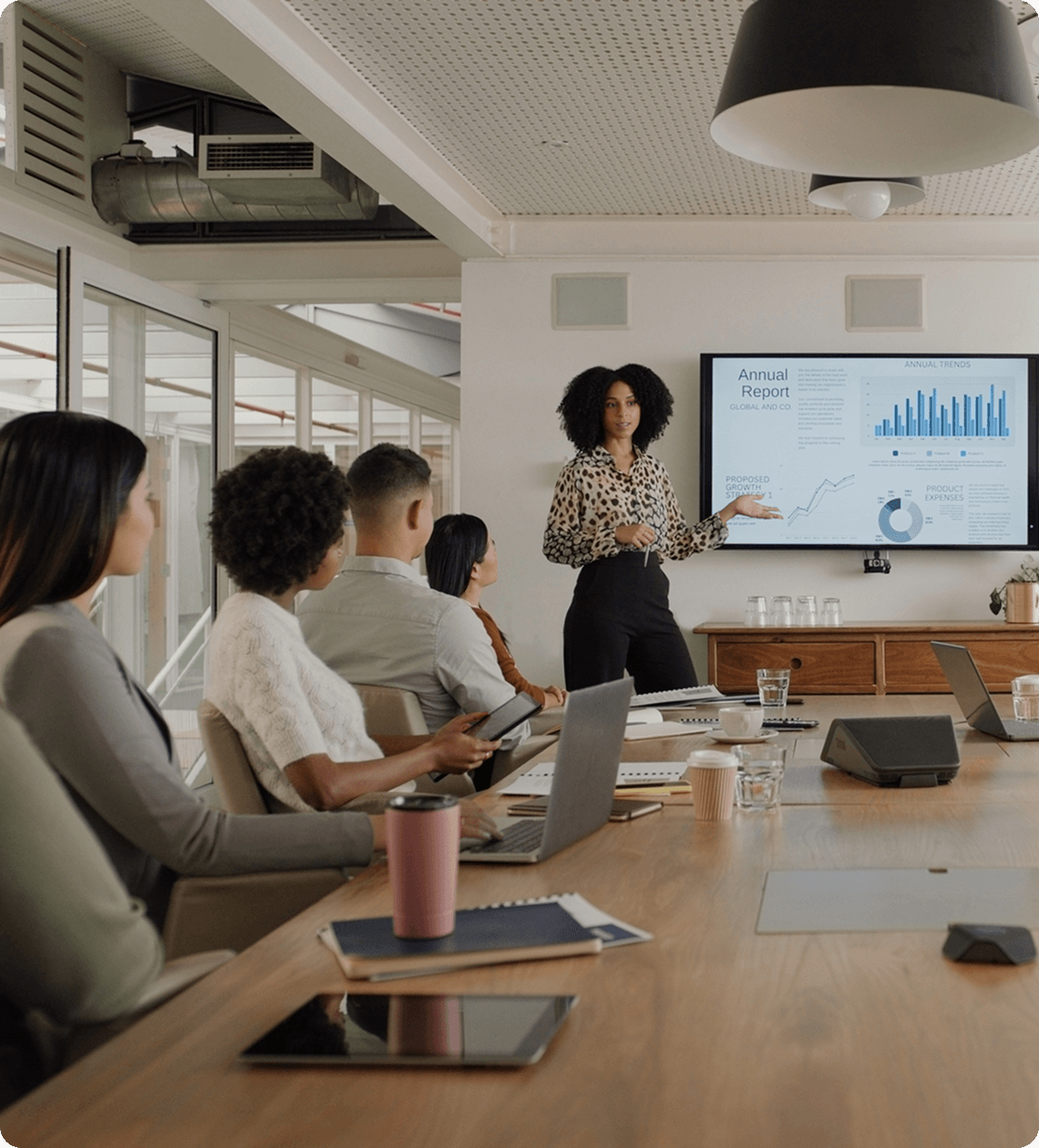 Office presentation with charts on screen.