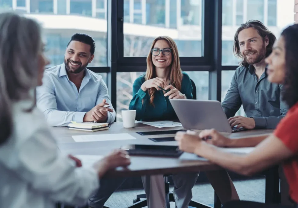 A diverse team engaged in a business meeting around a table.